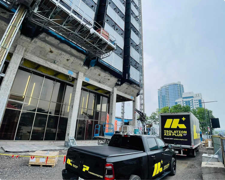 Camions d'Isolation Air-Plus présents sur un chantier commercial de la région de Québec